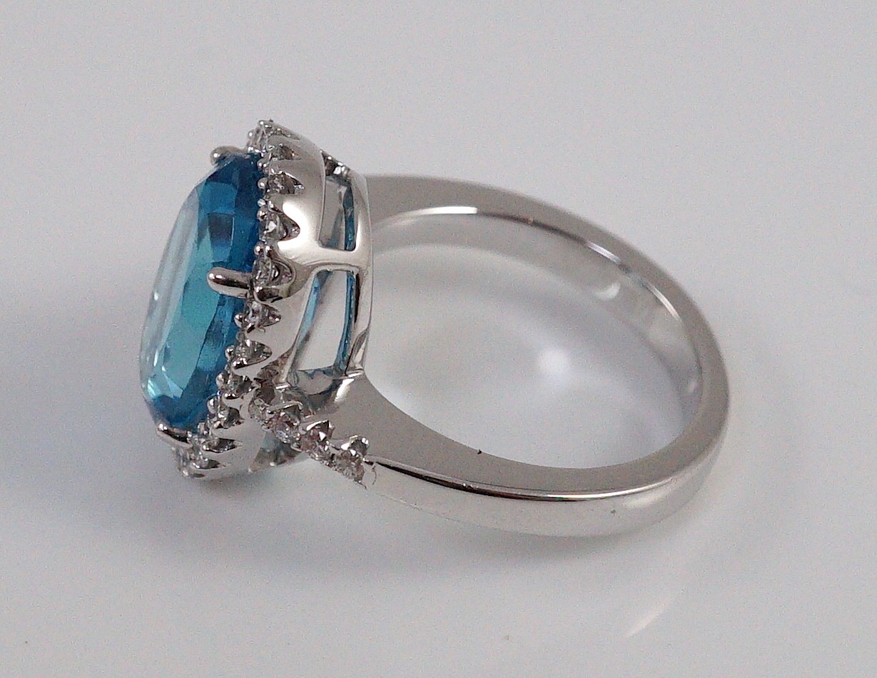 A modern 18k white gold, blue topaz and diamond oval cluster dress ring